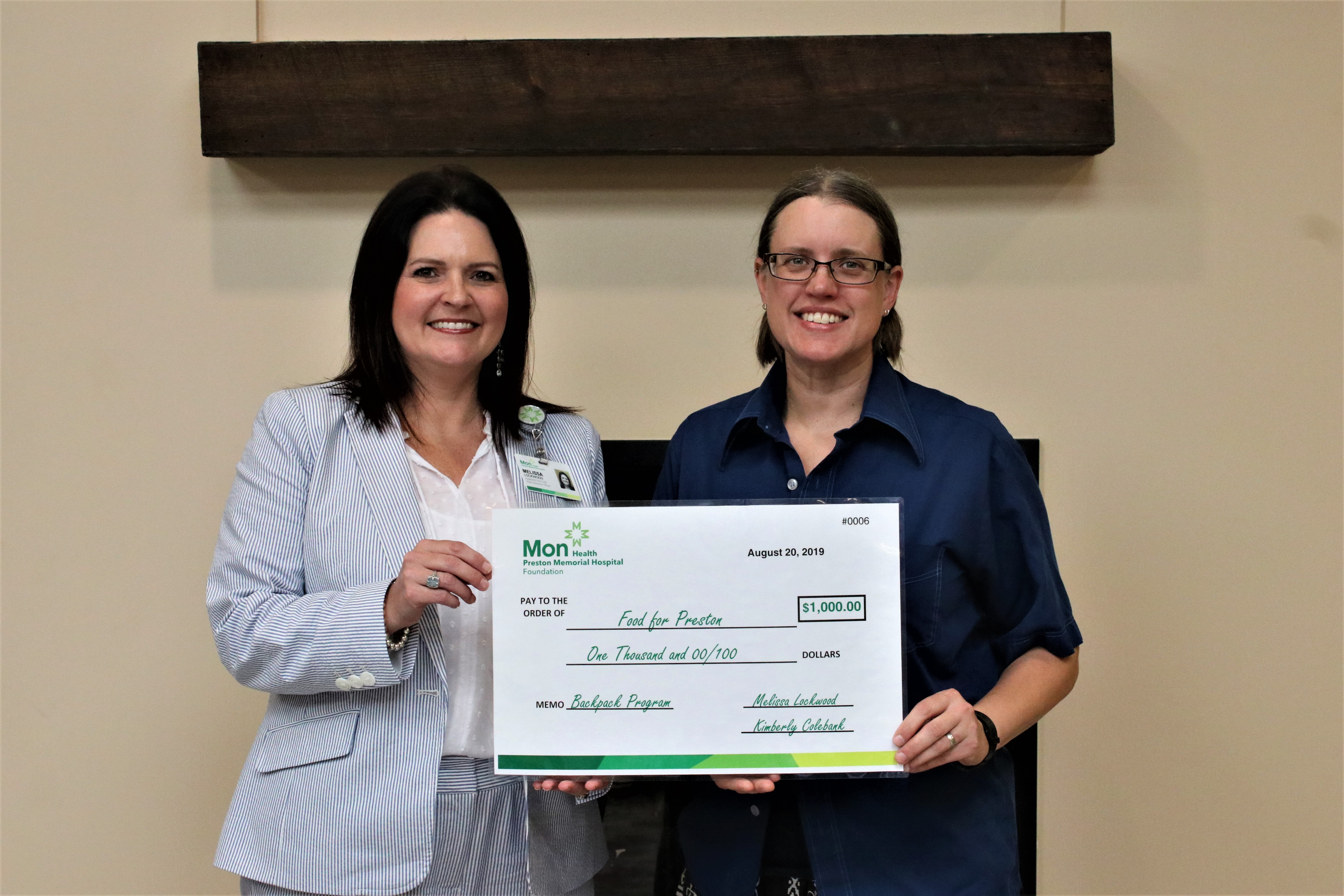 two women holding check